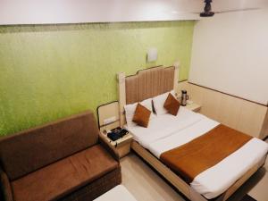een slaapkamer met een bed en een bank bij HOTEL VISHAL PLAZA in Puri