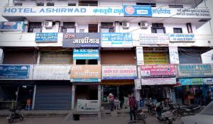 un edificio con molti cartelli sul lato di Hotel Ashirwad a Jabalpur