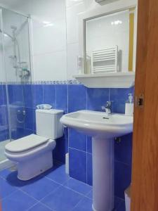 een blauwe badkamer met een toilet en een wastafel bij Loft By Vialia in Vigo