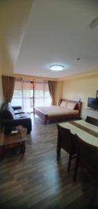 a large living room with a bed and a couch at PRIVATE suite AT CAMP JOHN HAY FOREST LODGE in Camp John Hay