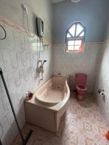 a bathroom with a tub and a pink toilet at Pasidu Villa in Kalutara