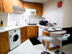 a kitchen with a washing machine and a sink at Spacious Studio apartment in the Heart of JLT in Dubai