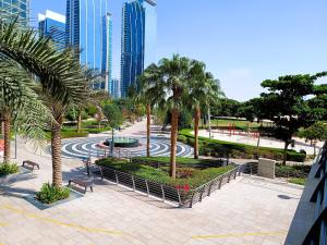 a park with palm trees and a fountain and buildings at Spacious Studio apartment in the Heart of JLT in Dubai