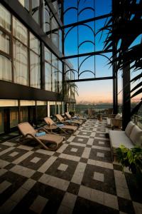 a row of chairs in a building with a checkered floor at May De Ville Luxury Hotel & Spa in Hanoi