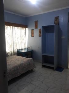 1 dormitorio con cama y pared azul en RockVilla GuestHouse Njabini SouthKinangop Nyandarua, en South Kinangop