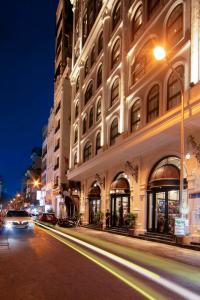 uma rua da cidade à noite com um edifício em May De Ville Luxury Hotel & Spa em Hanói