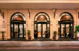 May De Ville Luxury Hotel & Spa في هانوي: رجلان يقفان في مدخل المبنى