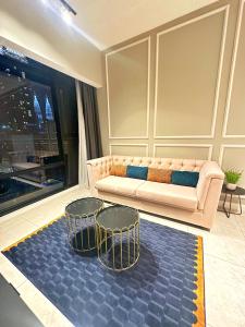 Axon Residence By Leo Suites في كوالالمبور: غرفة معيشة مع أريكة وكرسيين