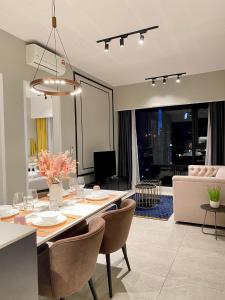 Axon Residence By Leo Suites في كوالالمبور: غرفة طعام وغرفة معيشة مع طاولة وكراسي