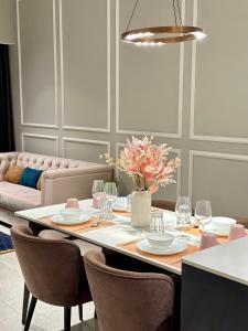 Axon Residence By Leo Suites في كوالالمبور: غرفة طعام مع طاولة مع كراسي وأريكة