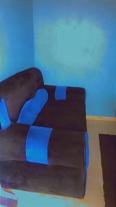 Schlafzimmer mit einem Bett mit blauer Bettwäsche in der Unterkunft K House in Kampala
