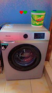 eine Waschmaschine mit einer Schüssel darüber in der Unterkunft K House in Kampala