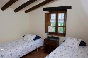 a bedroom with two beds and a window at Masia Sapera in Pontons +18 photos
