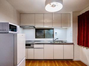 a kitchen with white cabinets and a stainless steel refrigerator at Sumiyoshi Marie - Vacation STAY 12161 in Osaka
