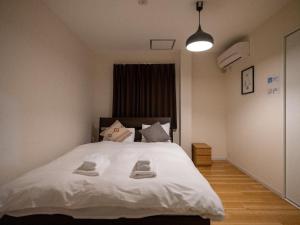 a bedroom with a white bed with two towels on it at Sumiyoshi Marie - Vacation STAY 12161 in Osaka