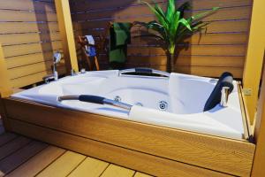 a bath tub in a room with a plant in it at Sumiyoshi Marie - Vacation STAY 12161 in Osaka