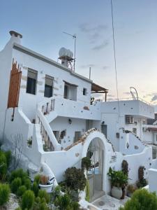 a white house with a staircase leading up to it at Sonia`s luxury apartment with jacuzzi in Kamilari