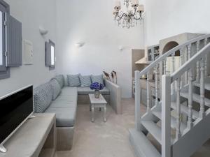 a living room with a blue couch and a staircase at Palmariva Villas in Fira