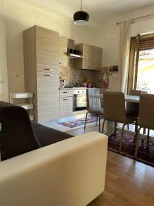uma sala de estar com um sofá e uma mesa com cadeiras em Claudia' s apartment Ladispoli em Ladispoli