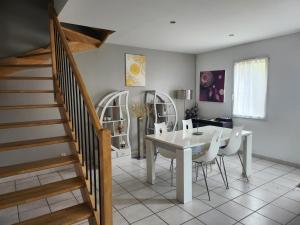 a dining room with a table and chairs and a staircase at Maison tout confort in Nîmes