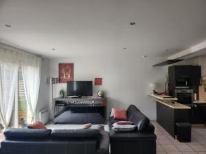 sala de estar con sofá y cocina en Maison tout confort en Nimes