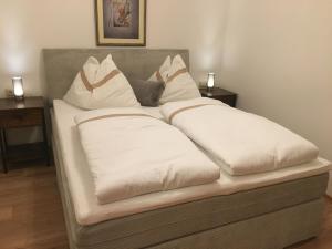 a bed with white pillows on top of it at Haus Christina in Sankt Johann im Pongau