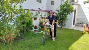 two women sitting on a bike in a yard at Villa homestay Misa in Phan Thiet