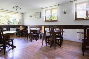 uma sala de jantar com mesas e cadeiras de madeira em Pensjonat Pod Długą Polaną em Nowy Targ