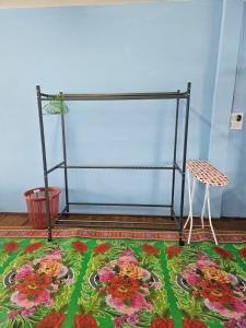 Zimmer mit einem Blumenteppich, einem Tisch und einem Stuhl in der Unterkunft Paksong Brand New- Two-story house in Muang Pakxong