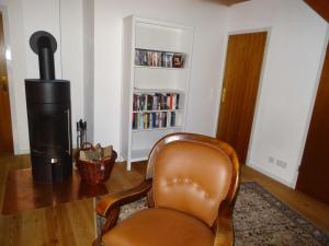 a leather chair in a living room with a fireplace at Ferienhaus Urlaub am Meer in Maasholm-Bad