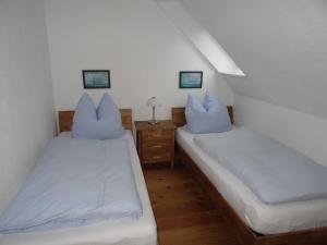 two beds in a room with white sheets and pillows at Ferienhaus Urlaub am Meer in Maasholm-Bad