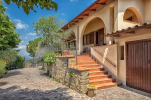 ein Haus mit Treppen und einem Tor auf einer Straße in der Unterkunft Villa Querceto With Pool e Tennis Private - Happy Rentals in Loro Ciuffenna