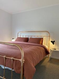 a bedroom with a bed with a metal frame at Long Island Retreat II (by the river with wi-fi) in Murray Bridge