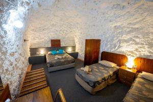 a bedroom with two beds and a cave wall at White Cliffs Underground Motel in White Cliffs