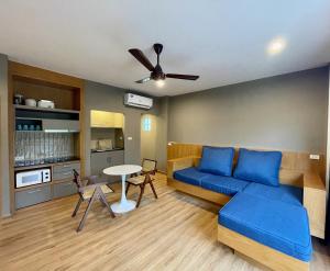 un soggiorno con divano blu e tavolo di Room Actually Service Apartment a Karon Beach