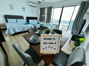 een woonkamer met een tafel met een welkomstbord bij 1-5 Pax Comfy Trefoil Studio-Walk to Setia City Mall & Setia City Convention Centre in Shah Alam