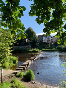 un río con una fila de escalones en el agua en The Snug Centre of Morpeth en Morpeth