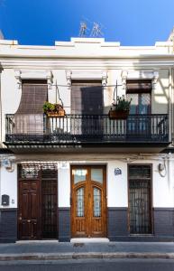 ein weißes Gebäude mit Holztüren und einem Balkon in der Unterkunft Family ARTpartment in Valencia