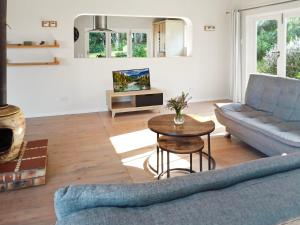 ein Wohnzimmer mit einem Sofa und einem Tisch in der Unterkunft Beehaven Sunset Paradise in Kenton on Sea