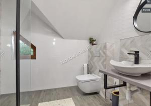 uma casa de banho com um lavatório e um WC em APARTAMENTY UL.SARNIA em Wisla