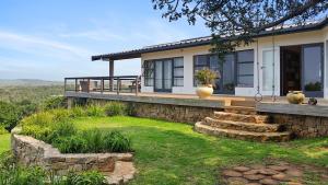 a house with a stone retaining wall and a porch at Beehaven Sunset Paradise in Kenton on Sea