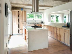 eine Küche mit weißen Arbeitsflächen sowie Holzböden und -fenster in der Unterkunft Beehaven Sunset Paradise in Kenton on Sea