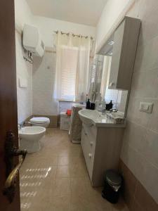 uma casa de banho com um lavatório, um WC e um espelho. em Claudia' s apartment Ladispoli em Ladispoli