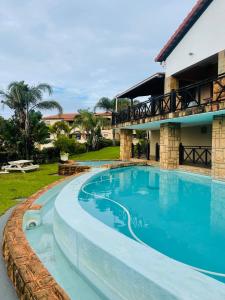 a swimming pool in front of a house at Private Apartment at Ocean View Villas in Port Edward