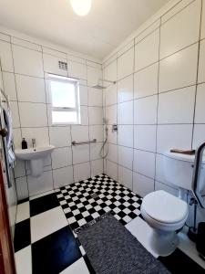 ein Badezimmer mit schwarz-weiß kariertem Boden in der Unterkunft Verregaande Cottage with hot tub in Agulhas