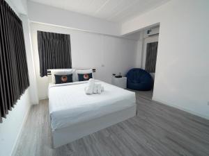 a bedroom with a white bed with two white towels on it at RoomQuest North Pattaya Light Collection in Pattaya North