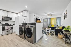 a kitchen with two washing machines and a living room at NEW! Modern Comforts w/ 4Beds/3BR Sleeps 8 in Atlanta