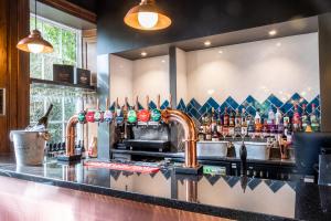 a bar with a counter with a lot of drinks at Park House Hotel in Shifnal