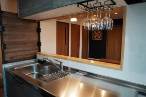 a kitchen with a stainless steel sink and a mirror at 【 STAY Chill ~omura~】長崎空港から車で10分！ in Omura