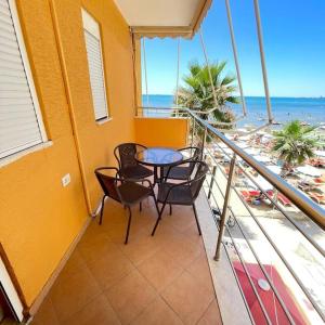 een balkon met een tafel en stoelen en het strand bij Apartment Julia in Durrës